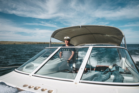 the captain of the yacht at the helm controls the boat on the water.のeditorial素材