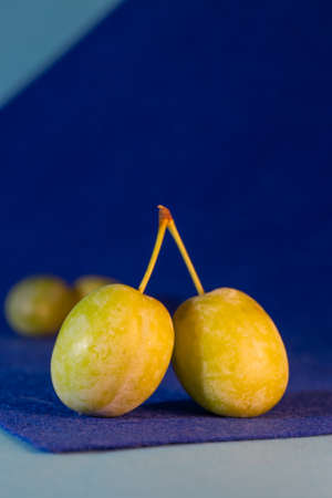 plum fruit with leaves close-up on a blue background.の写真素材