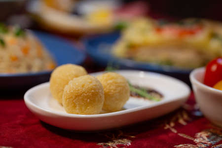 cheese balls on a white plate on the table in a cafe