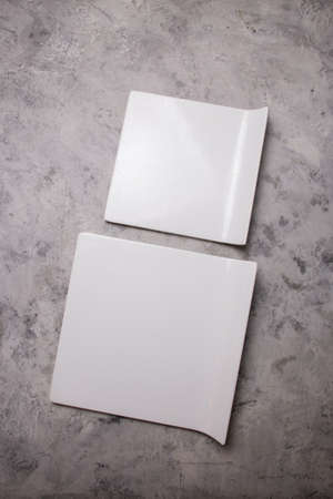 white ceramic square plates on a concrete background.の写真素材
