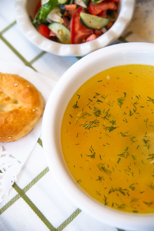 chicken soup with salad and bread on a bell tablecloth.の写真素材