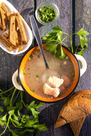 top view of fish soup ear with croutons and greens on a blue wooden backgroundの写真素材