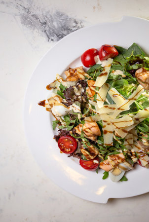 top view salad with shrimp and tomatoes, cheese and herbs on a plate in a restaurant.の写真素材