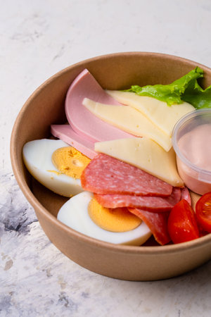 breakfast sausage, cheese, egg and tomatoes. breakfast in a craft plateの写真素材