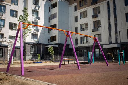 A new colorful playground in a sunny summer courtyard among residential high-rise buildings.の写真素材