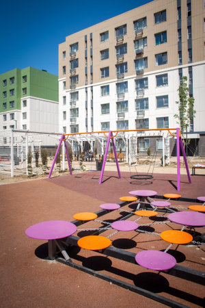 A new colorful playground in a sunny summer courtyard among residential high-rise buildings.の写真素材