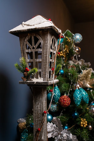Christmas wooden lantern with garlands and toys on the background of a Christmas tree indoorsの写真素材