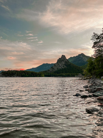 lake in the resort area of Borovoye in Kazakhstan against the background of a mountain at sunsetの写真素材