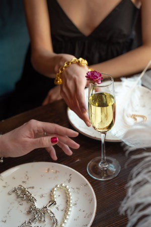 close-up of women's hands reaching for a glass of wine.の写真素材