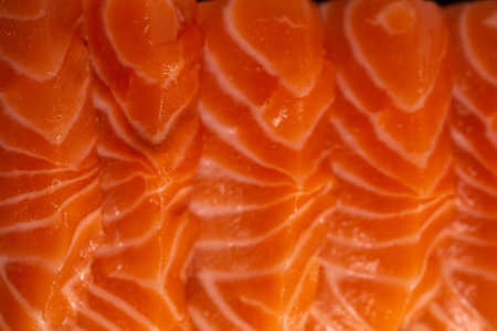 Close-up of fresh raw salmon fillet. Isolated on white background. Salmon is a type of fish that is often used in sushi and sashimi. It has a delicate flavor and a slightly pink color.の写真素材