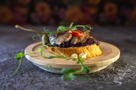 Rustic wooden plate with open faced sandwich with beef tenderloin and roasted mushrooms, garnished with fresh sprouts.の写真素材