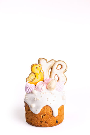 A small traditional Easter cake with yellow icing and a cute chick decoration on top, isolated on a...