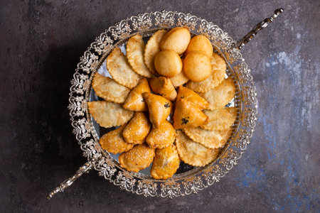 An assortment of delicious pastries, including baklava, borek, and bourekas, is artistically arranged on a silver platter.の写真素材