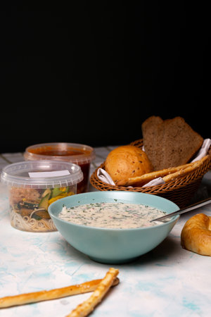 A plate of okroshka and fresh bread on the table.