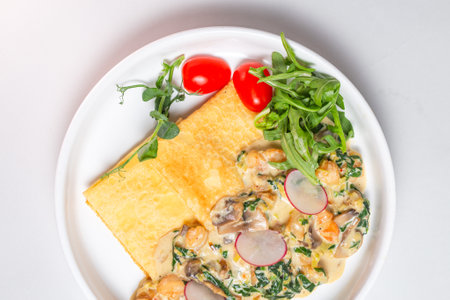 Savory crepe with creamy mushroom sauce, fresh greens on a white plate. Perfect for a light and satisfying meal.の写真素材