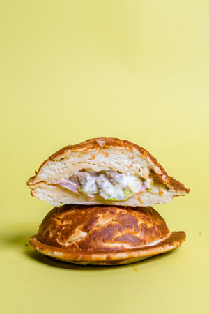 Half of burger with no top bread and a fried egg on top of the patty, isolated on a pastel yellow background.の写真素材