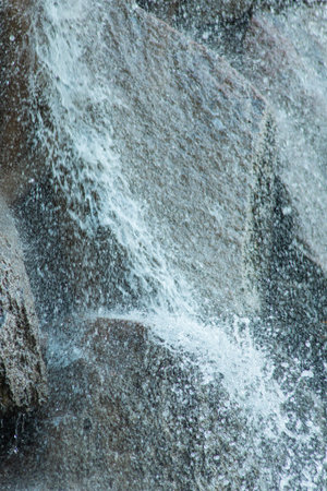 Close-up of water flowing over rock natural texture and motion. High quality photo