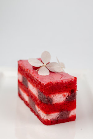 Close-up of red velvet cake slice with white cream layer. Captures luxury and delicacy. Perfect for bakeries and wedding catalogs.の写真素材