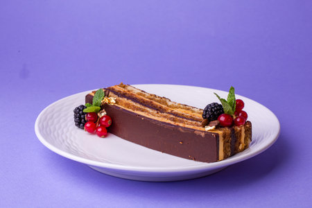 Chocolate cake with berries - top view on purple, luxury in every layer