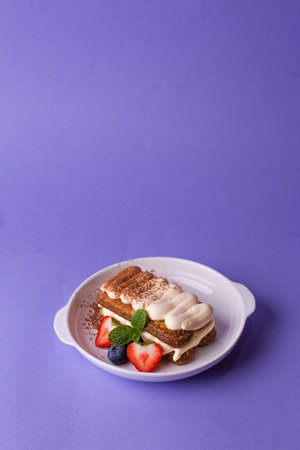 Tiramisu with berries on purple - classic dessert in modern plating