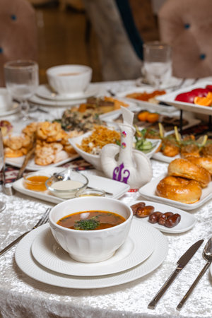Elegant soup bowl with fresh herbs on white plate at lavish breakfast buffetの写真素材
