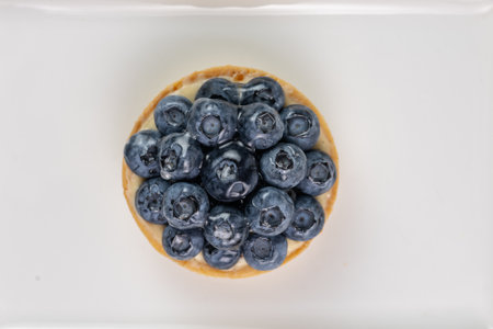 Top view of mini tart with blueberries, fresh summer sweetness on white backgroundの写真素材