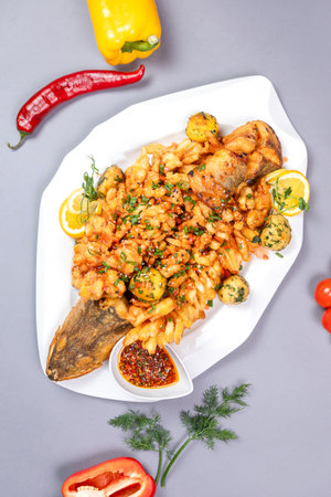 Top view of fish with crispy crust and lemon - appetizing dish on gray background.の写真素材