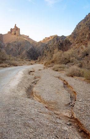 Mountain gravel road winding through dramatic canyon cliffs