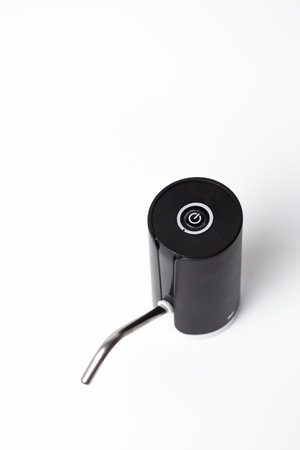 Close-up of black touchless automatic soap dispenser with curved metal spout on white background.