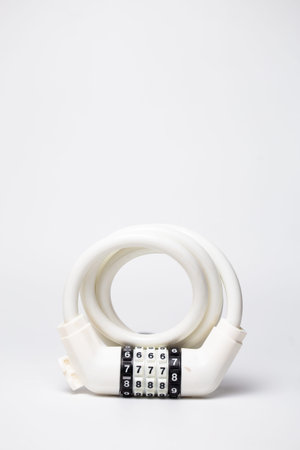 White coiled combination cable lock for bike and scooter security on white background.の写真素材