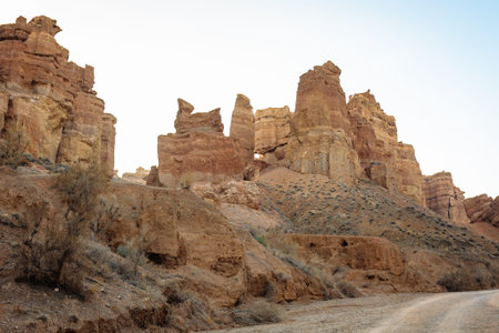Towering eroded red sandstone cliffs and massive boulders create a stunning, otherworldly landscape in Charyn Canyon, Kazakhstan's natural wonder just 200 km from Almatyの写真素材