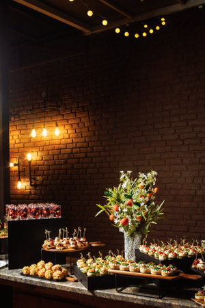 Elegant catering buffet in brick loft with canapes and floral centerpiece.