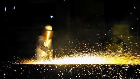 worker using torch cutter to cut through metal の写真素材