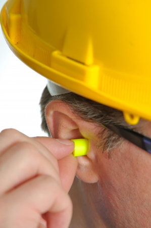 yellow earplug into the ear の写真素材