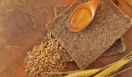 Sliced integral bread and honey spoon