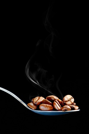 spoon with brown roasted coffee beansの写真素材