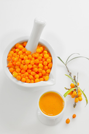 Sea buckthorn Berries and juice on white の写真素材