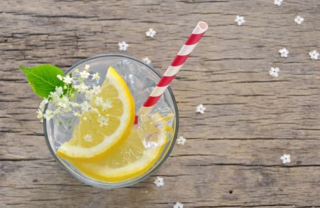 elderberry flower flavored summer refreshment cocktail with sliced lemon on old wooden table, viewed from aboveの写真素材