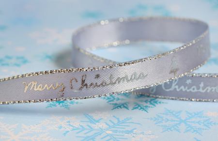 Silver christmas ribbon isolated on blue の写真素材
