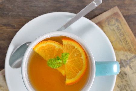 cup of tea and orange slices on old wood tableの写真素材