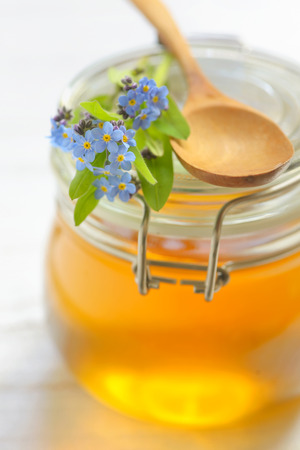 glass jar full of honey and spoonの写真素材