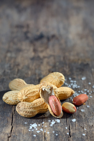 Dried peanuts in closeup on wooden backgroundの写真素材