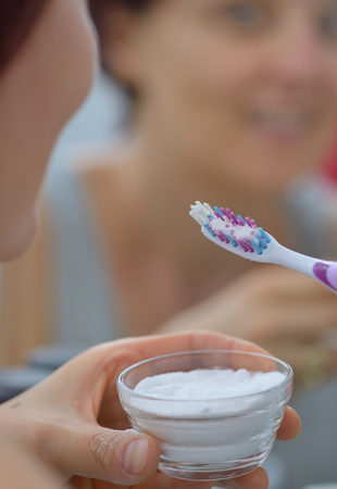Woman brightening teeth with sodium bicarbonateの写真素材