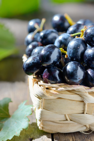 grapes in a basket on wooden backgroundの写真素材