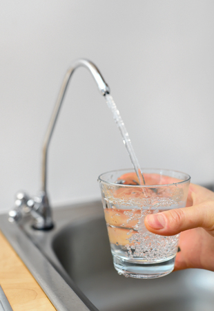 Filling glass with filtered waterの写真素材