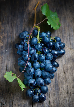 Bunch of red grapes on wooden table backgroundの写真素材