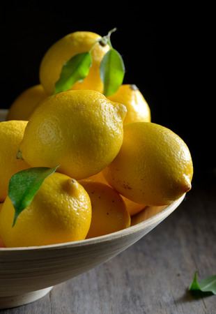 lemons with leaves on an old wooden tableの写真素材