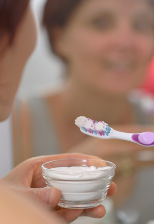 Woman brightening teeth with sodium bicarbonateの写真素材