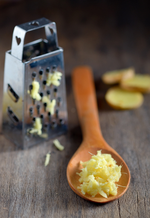 ginger in a wooden spoon on wooden tableの写真素材