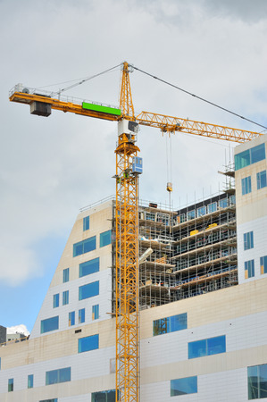 Working crane on a modern office building under constructionの写真素材